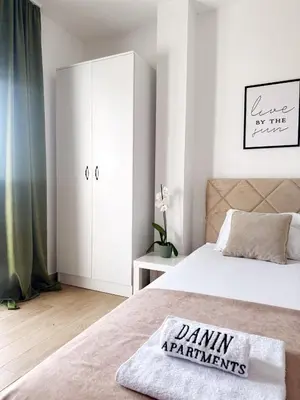 a bedroom with a bed and a white cabinet at Danin apartmani in Bar