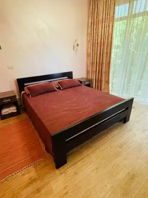 a bedroom with a large bed with red sheets and a window at Villa Premium S in Bar