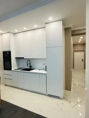 a kitchen with white cabinets and a sink at Apartmani Sunce in Bar