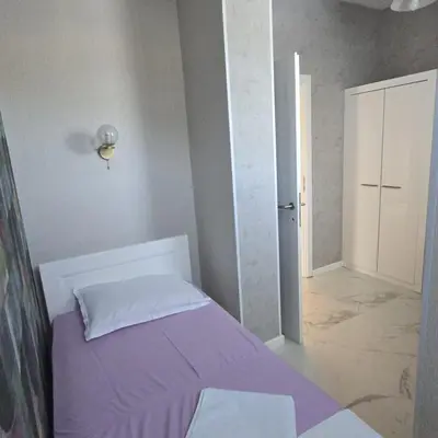 a bedroom with a bed with a purple blanket at Apartmani Sunce in Bar