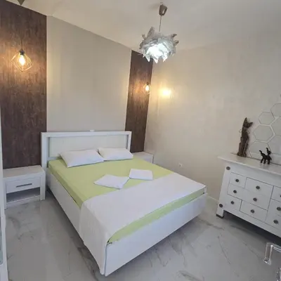 a bedroom with a white bed and a white dresser at Apartmani Sunce in Bar