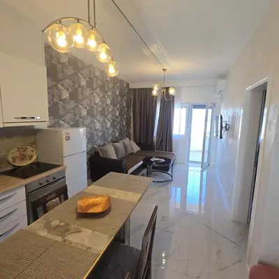 a kitchen and living room with a table and a dining room at Apartmani Sunce in Bar