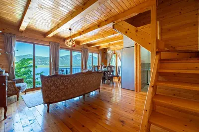 a living room with a staircase and a table and chairs at Villas Katarina Skadar Lake in Cetinje