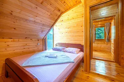 a bedroom with a bed in a wooden cabin at Villas Katarina Skadar Lake in Cetinje