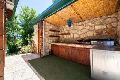 a kitchen with a stove and a stone wall at Villas Katarina Skadar Lake in Cetinje