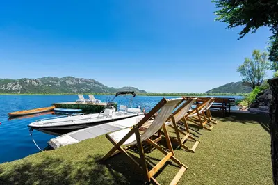 a boat is docked on the shore of a lake at Villas Katarina Skadar Lake in Cetinje