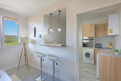 a kitchen with a counter and stools in a room at Harmony in Radanovići