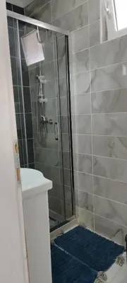 a bathroom with a shower with a blue rug at Harmony in Radanovići