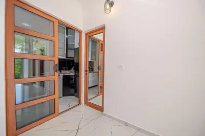 an open door leading into a kitchen with glass doors at The White House in Ðurmani