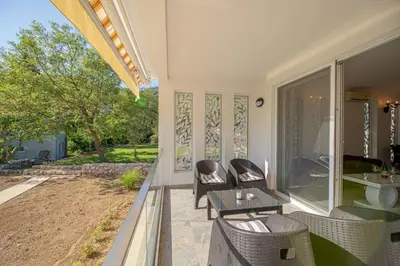 a patio with chairs and a table on a porch at The White House in Ðurmani