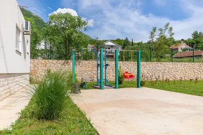 a playground in a yard next to a stone wall at The White House in Ðurmani