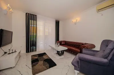 a living room with a couch and a tv at The White House in Ðurmani