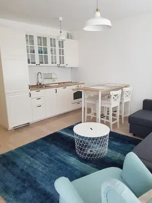 a living room with a table and a kitchen at Apartment Andrea in Budva