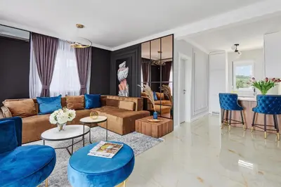 a living room with a brown couch and blue chairs at Kotor Rooftop Apartments in Kotor