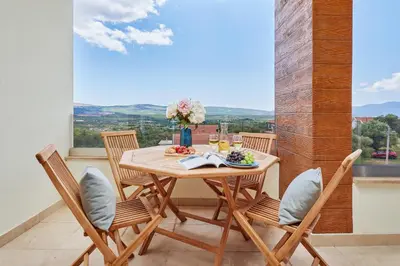 a dining room with a table and chairs and a window at Kotor Rooftop Apartments in Kotor
