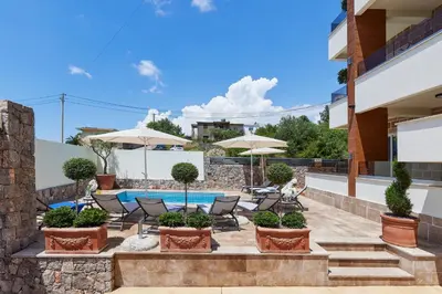 a patio with chairs and umbrellas and a swimming pool at Kotor Rooftop Apartments in Kotor