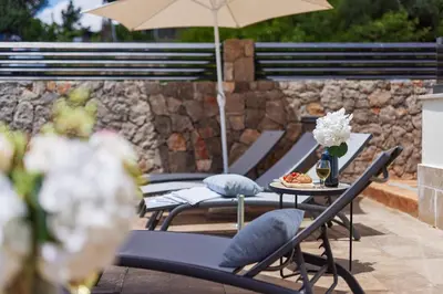a group of chairs and tables with an umbrella at Kotor Rooftop Apartments in Kotor