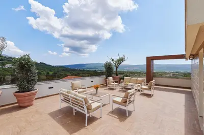 a patio with a table and chairs on a balcony at Kotor Rooftop Apartments in Kotor