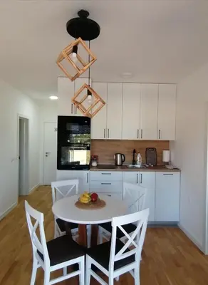 a kitchen with a table and chairs in a room at Vegi Apartments in Bar