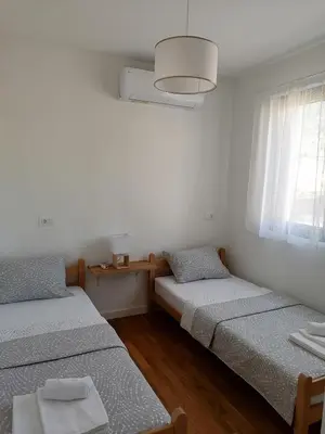 two beds in a white room with a window at Vegi Apartments in Bar