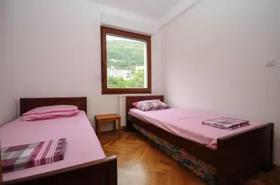 two beds in a room with a window at Apartment Jana in Petrovac na Moru