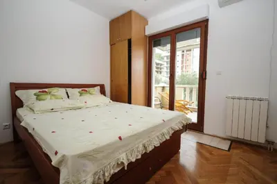 a bedroom with a bed and a large window at Apartment Jana in Petrovac na Moru