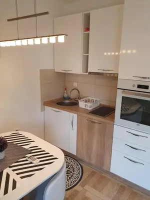a kitchen with white cabinets and a stove top oven at Apartman Bečiči - Budva - Free Parking in Budva