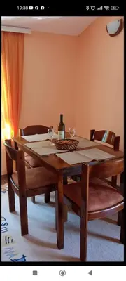a wooden table with two wine glasses on top of it at Village house Iva in Virpazar