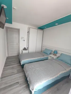two beds in a bedroom with blue and white at SOVA smart HOUSE in Bar