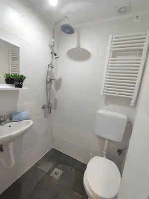 a white bathroom with a toilet and a sink at SOVA smart HOUSE in Bar