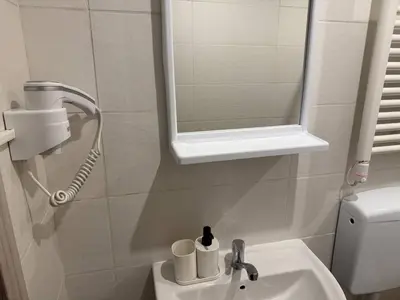 a bathroom with a sink and a mirror and a toilet at SOVA smart HOUSE in Bar