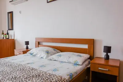 a bedroom with a bed with two night stands and two lamps at Kashoxha Apartments with SeaView in Ulcinj