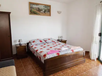 a bedroom with a bed and a picture on the wall at Kashoxha Apartments with SeaView in Ulcinj