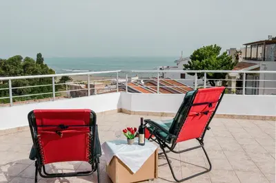 two chairs and a table with flowers on a balcony at Kashoxha Apartments with SeaView in Ulcinj