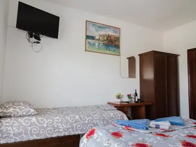 a bedroom with two beds and a flat screen tv at Kashoxha Apartments with SeaView in Ulcinj