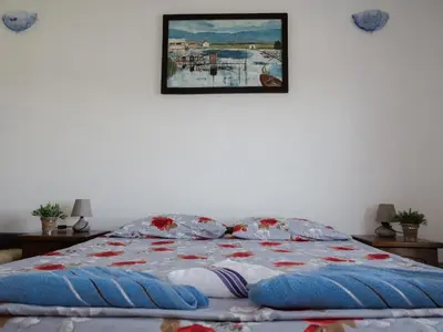 a bedroom with a bed with a picture on the wall at Kashoxha Apartments with SeaView in Ulcinj