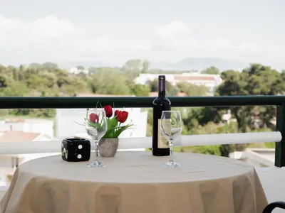 a table with a bottle of wine and two glasses at Kashoxha Apartments with SeaView in Ulcinj