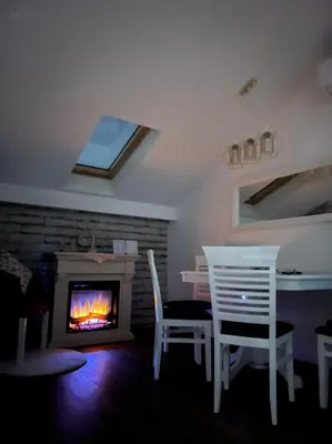 a living room with a table and chairs and a fireplace at Apartman Senka in Budva