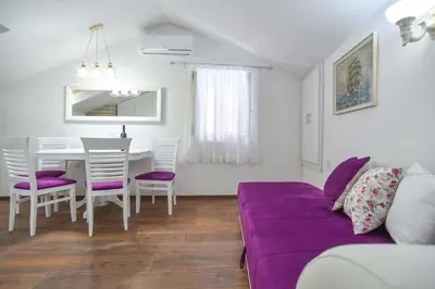 a living room with a purple couch and a table at Apartman Senka in Budva
