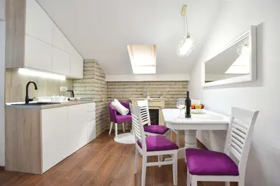 a kitchen with a table and purple chairs in a room at Apartman Senka in Budva
