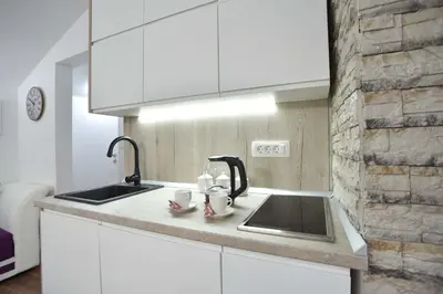 a kitchen with a sink and two mugs on a counter at Apartman Senka in Budva