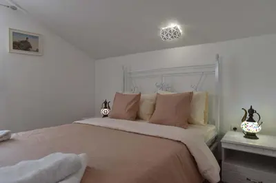 a bedroom with a large bed with pink pillows at Apartman Senka in Budva