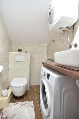 a bathroom with a washing machine and a sink at Apartman Senka in Budva