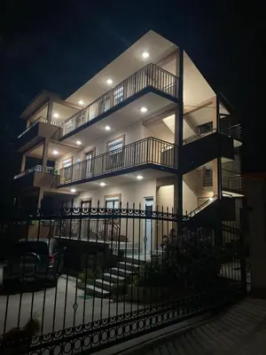 a large building with a fence in front of it at Lara i Mirko Apartments in Mrčevac