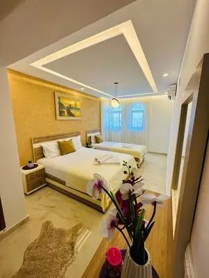 a hotel room with two beds and a vase with flowers at Luxury Villa Ulcinj in Ulcinj