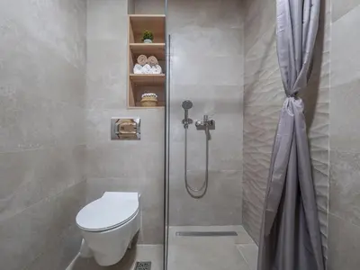 a bathroom with a shower with a toilet and a shower curtain at Luxury modern apartment 8min walk from beach in Becici in Rafailovici