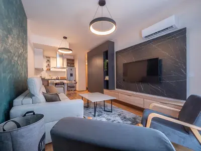 a living room with a couch and a flat screen tv at Luxury modern apartment 8min walk from beach in Becici in Rafailovici