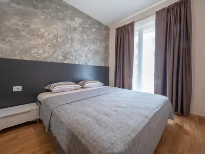 a bedroom with a bed and a large window at Luxury modern apartment 8min walk from beach in Becici in Rafailovici