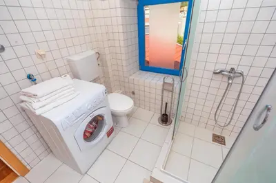 a bathroom with a toilet and a washing machine at Altomare with Sea View in Petrovac na Moru