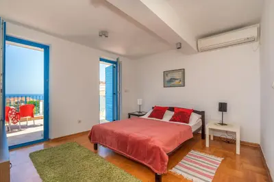 a bedroom with a bed and a large window at Altomare with Sea View in Petrovac na Moru
